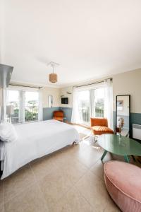 1 dormitorio con 1 cama grande y 1 mesa en Résidence Chateau d'Acotz - Appartements avec piscine à 600m des plages à Saint-Jean-de-Luz, en San Juan de Luz