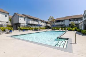 a swimming pool in the courtyard of a apartment building at "INACTIVE UNBOOKABLE - 5 mins from Disneyland and Convention Center - Your Perfect SoCal Getaway!" in Anaheim