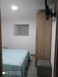 Habitación con cama y silla junto a una puerta en O RECUNCHO DE BERE, en Ribadeo