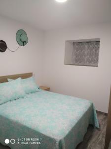1 dormitorio con 1 cama con edredón azul en O RECUNCHO DE BERE en Ribadeo