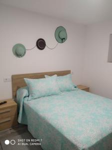 ein Schlafzimmer mit einem Bett mit zwei Lichtern an der Wand in der Unterkunft O RECUNCHO DE BERE in Ribadeo