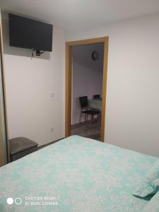 a bedroom with a bed with a television and a table at O RECUNCHO DE BERE in Ribadeo