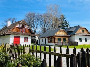 2 casas con puertas rojas y una valla de madera en Chalupy Betlém Hlinsko, en Hlinsko