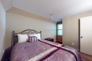 a bedroom with a bed with a purple comforter at Mountain Majesty in Stateline