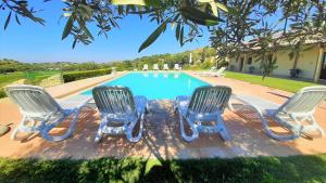 a group of four chairs and a swimming pool at Villa Maria in Chiaramonte Gulfi