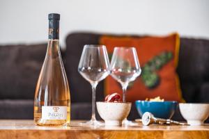 una bottiglia di vino e due bicchieri di vino su un tavolo di Le Nid d'Aigle - Le Pont Romain a Vaison-la-Romaine
