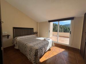 1 dormitorio con cama y ventana grande en Dúplex Río Madera, en Segura de la Sierra