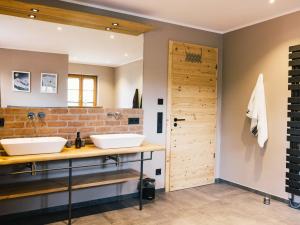 baño con 2 lavabos y pared de ladrillo en Wolke 9A en Traunstein