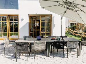 a patio with a table and chairs and an umbrella at Wolke 9A in Traunstein