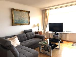sala de estar con sofá y TV de pantalla plana en Dara‘s Traumblick en Sierksdorf