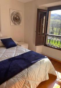 una camera con un letto e una grande finestra di Pantin Corao Casa Rural a Cangas de Onís