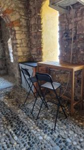 2 sillas sentadas junto a un escritorio en una habitación de piedra en Il Rifugio sul Golfo, en Tellaro