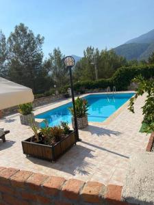 a swimming pool with a light pole and a clock next to it at A quiet, peaceful accommodation in Fethiye