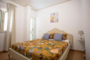 ein Schlafzimmer mit einem Bett mit einer bunten Decke in der Unterkunft Villa Dyrrahu in Golem