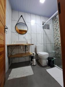 Un baño con inodoro, lavabo y espejo. en Recanto Pôr do Sol, en Urubici