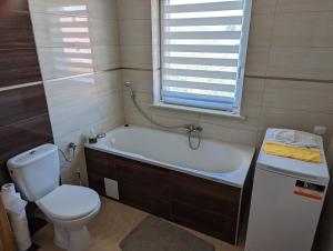 a bathroom with a tub and a toilet and a sink at Apartament Osak in Stare Juchy