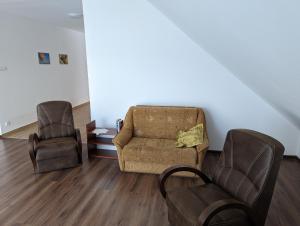 uma sala de estar com um sofá e duas cadeiras em Apartament Osak em Stare Juchy