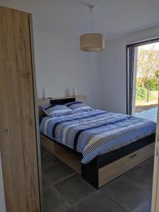 Bett mit blauer und weißer Decke in einem Zimmer in der Unterkunft maison angles in Angles