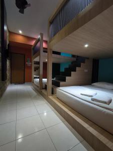 a bedroom with two bunk beds and a staircase at GOLDEN GUEST HOUSE KUANTAN in Kuantan