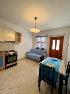 una cucina e un soggiorno con tavolo e divano di {Perla d'aMare ~ Zaffiro} Appartamento sul mare a San Benedetto del Tronto