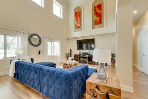 uma sala de estar com um sofá azul e uma mesa em Contemporary Brandon Home with Pool and Game Room em Brandon
