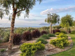 einen Garten mit Pflanzen und Bäumen und dem Meer in der Unterkunft Villas Phos and Kallos in Kissamos