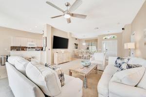 Una sala de estar con muebles blancos y un televisor de pantalla plana. en Heron Glen Hideaway, en North Fort Myers