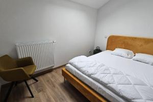 a bedroom with a bed and a chair at La Grande Mouette in Thonon-les-Bains