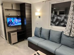 a living room with a couch and a tv at Mobilhome Luminosa tt équipé 6/8 pers in Les Mathes