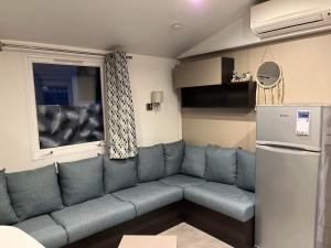 a living room with a couch and a window at Mobilhome Luminosa tt équipé 6/8 pers in Les Mathes
