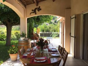 una mesa de madera con sillas en el patio en Villa Hibiscus, en Antibes