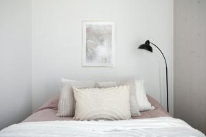 a bedroom with a bed with a pillow and a lamp at Woodrise Apartment 