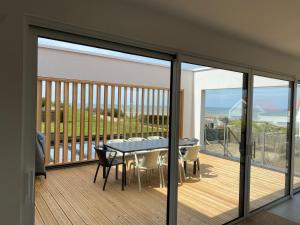 a balcony with a table and chairs on a deck at Villa - Cap Blanc-Nez in Sangatte