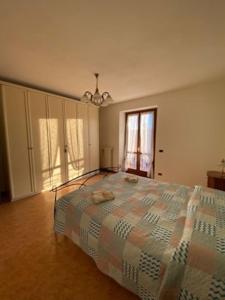 una grande camera da letto con un letto e una finestra di Appartamento Angolo Fiorito a Provaglio Val Sabbia