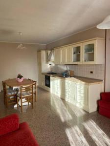 una cucina e una sala da pranzo con tavolo e cucina di Appartamento Angolo Fiorito a Provaglio Val Sabbia