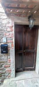 a wooden door in a brick wall with a box at La Terrazza sul Borgo in Mombaldone