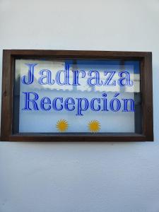 un panneau dans un cadre en bois sur un mur orné de fleurs dans l'établissement Hostal Jadraza, à Zahara de los Atunes