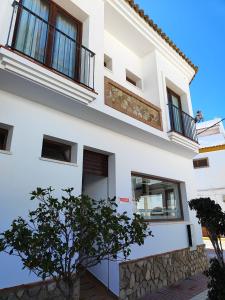 une maison blanche avec un arbre en face dans l'établissement Hostal Jadraza, à Zahara de los Atunes