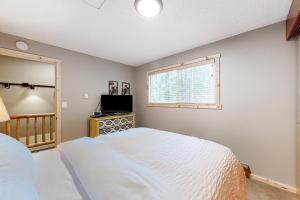 ein Schlafzimmer mit einem weißen Bett und einem Fenster in der Unterkunft Wooded Wonder in Rhododendron