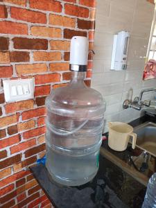 a large bottle of water sitting next to a sink at Joy House - 1 bhk Cozy entire house in Ooty