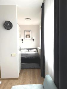 a bedroom with a bed and a clock on the wall at Apartamentai centre in Klaipėda