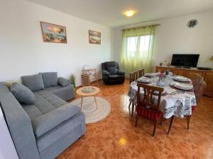 a living room with a couch and a table at Villa Rosa Apartman in Loborika