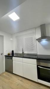 eine Küche mit einem Waschbecken und einem Fenster in der Unterkunft Light in Vila-real, central apartment with office in Villareal