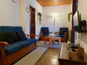 een woonkamer met een bank en 2 stoelen bij Rosinha Country House in Vale de Cambra