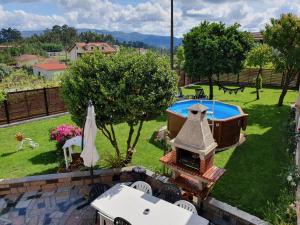 une arrière-cour avec une piscine et un barbecue en plein air dans l'établissement Rosinha Country House, à Vale de Cambra