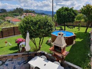 a backyard with a swimming pool and an outdoor grill at Rosinha Country House in Vale de Cambra