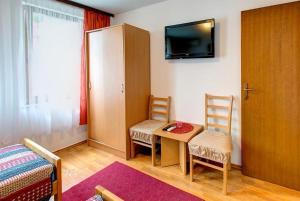 Habitación con mesa, 2 sillas y TV. en Apartments Stari most, en Mostar