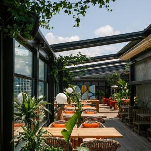 un patio con mesas, sillas y plantas en Apartments on Horizon en Batumi