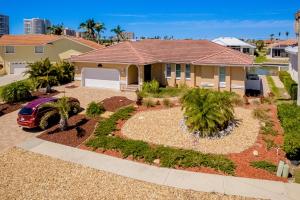 a house with a yard with palm trees and a driveway at Marco Beach Escape in Marco Island