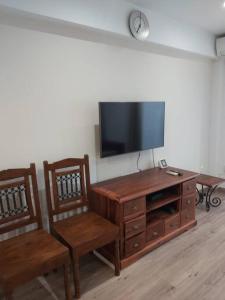 a living room with two chairs and a flat screen tv at Modern flat at Garbinet with WiFi in Alicante